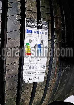 Dunlop SP247 (прицепная) 385/55 R22.5 160K(158L) 20PR - Фото протектора с этикеткой вблизи